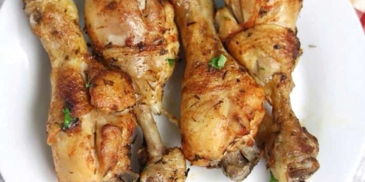 4 baked chicken drumsticks on a white plate.