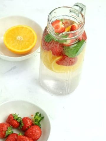 strawberries and orange slices with infused water on display.