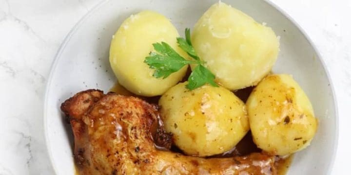 chicken leg served with gravy and potatoes.