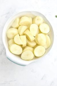 peeled and cut potatoes in a bowl.